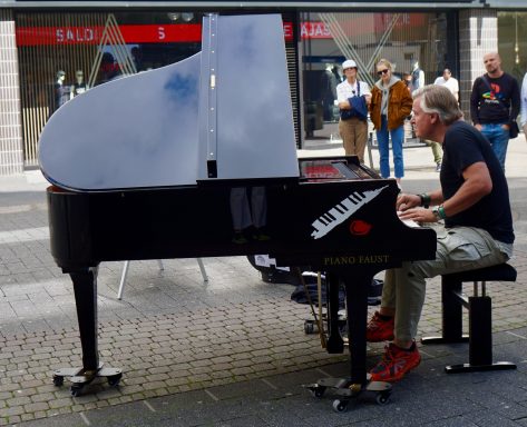 Carsten Esser von Cassollage spielt am Flügel auf der Schildergasse in Köln.