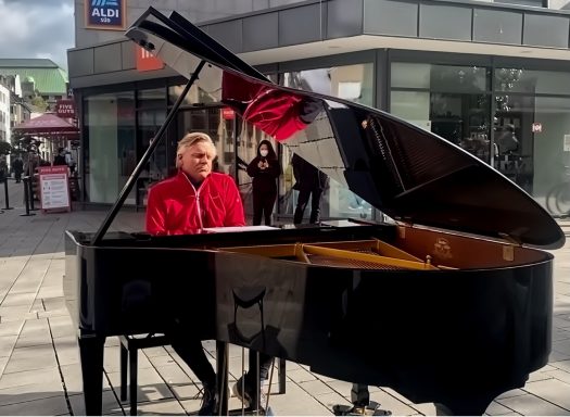 Carsten Esser am geöffneten schwarzen Flügel in der Düsseldorfer Altstadt.