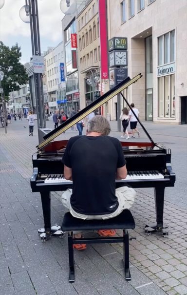 Carsten Esser von hinten am Flügel auf der Schildergasse in Köln.