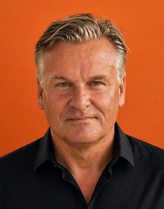 Porträt des Düsseldorfer Produzenten und Cassollage-Künstlers Carsten Esser vor orangefarbenem Hintergrund.
