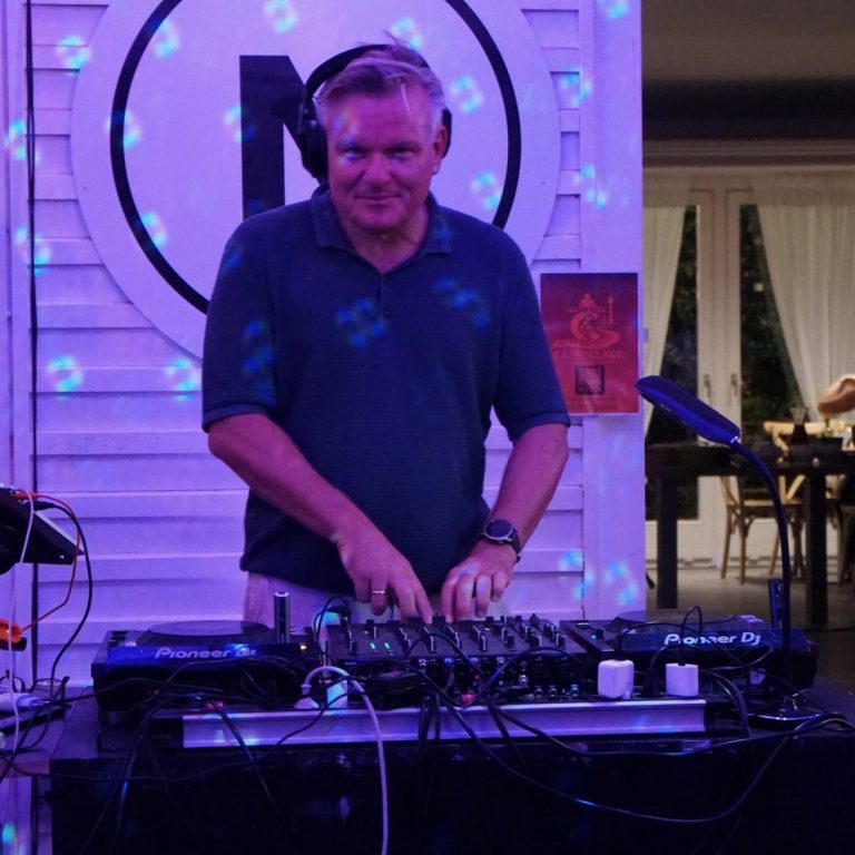 Carsten Esser von Cassollage mit Kopfhörern am DJ-Pult, mit Blick in die Kamera.